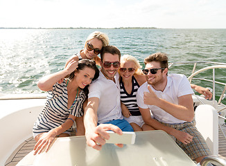 Image showing smiling friends sitting on yacht deck