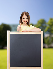 Image showing happy little girl with blank blackboard