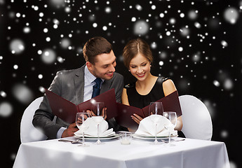 Image showing smiling couple with menus at restaurant