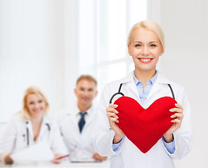 Image showing smiling female doctor with heart and stethoscope