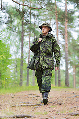 Image showing young soldier or hunter with gun in forest