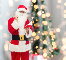 Image showing man in costume of santa claus with notepad