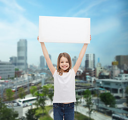 Image showing smiling little girl holding blank white board