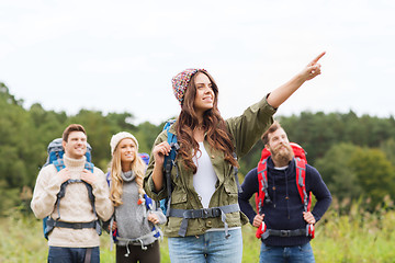 Image showing smiling hikers with backpacks pointing finger