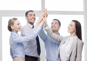 Image showing happy business team giving high five in office