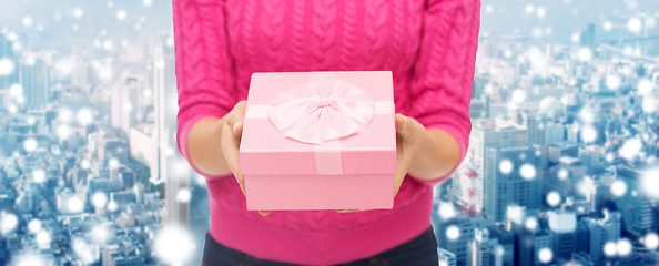 Image showing close up of woman in pink sweater holding gift box