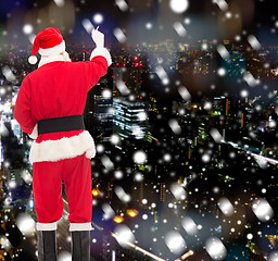 Image showing man in costume of santa claus writing something