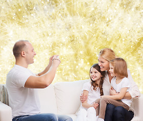 Image showing happy family with camera at home