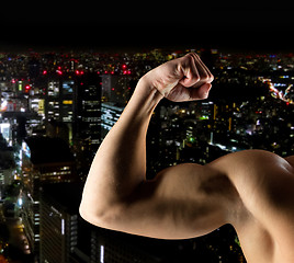 Image showing close up of young man showing biceps