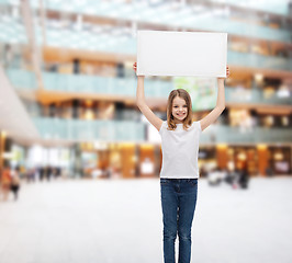 Image showing smiling little girl holding blank white board