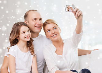 Image showing happy family with camera taking picture at home