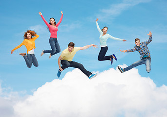 Image showing group of smiling teenagers jumping in air