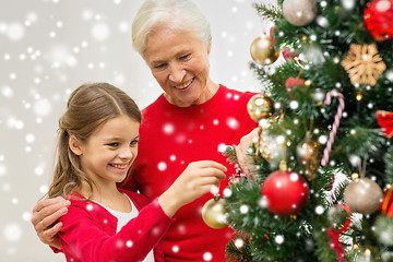 Image showing smiling family decorating christmas tree at home