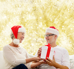 Image showing happy senior couple with gift box at home