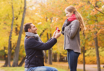 Image showing smiling couple with engagement ring in gift box