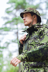 Image showing young soldier or hunter with gun in forest