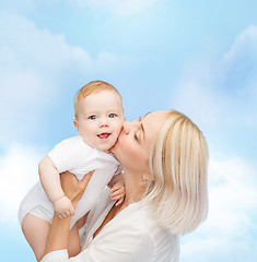 Image showing happy mother kissing smiling baby