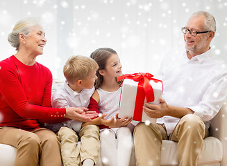 Image showing smiling grandparents and grandchildren with gift