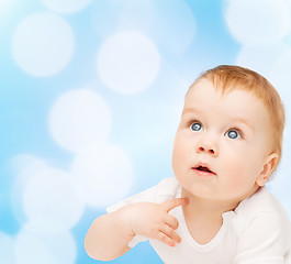 Image showing curious baby lying on floor and looking up