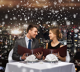 Image showing smiling couple with menus at restaurant