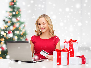 Image showing woman with gift boxes and laptop computer