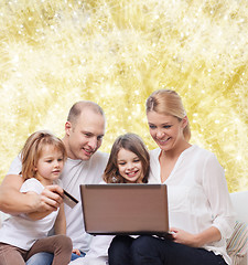 Image showing happy family with laptop computer and credit card