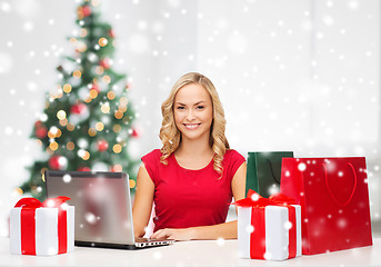 Image showing woman with gift boxes and laptop computer