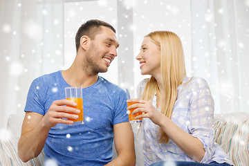 Image showing smiling happy couple at home drinking juice