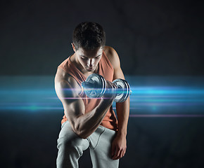 Image showing young man with dumbbell flexing biceps