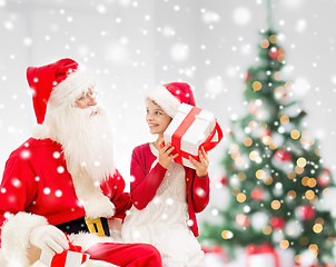 Image showing smiling little girl with santa claus and gifts