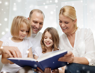 Image showing happy family with book at home