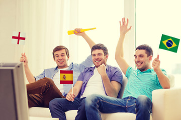 Image showing happy male friends with flags and vuvuzela