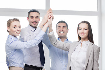 Image showing happy business team giving high five in office