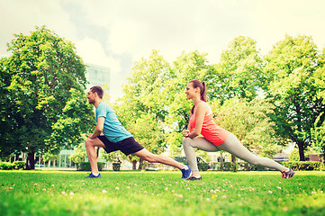 Image showing smiling couple stretching outdoors