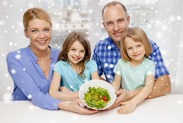 Image showing happy family with two kids showing salad in bowl