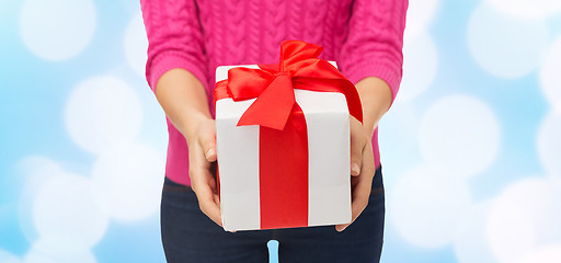 Image showing close up of woman in pink sweater holding gift box