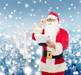 Image showing man in costume of santa claus with notepad