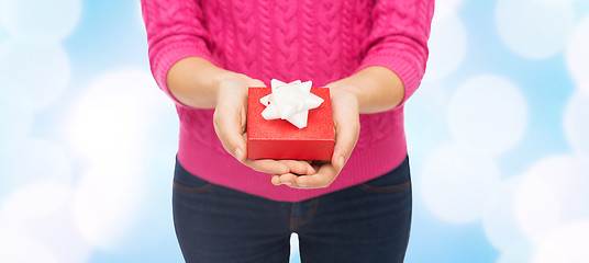 Image showing close up of woman in pink sweater holding gift box