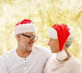 Image showing happy senior couple in santa helper hats