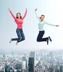 Image showing smiling young women jumping in air