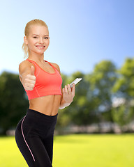 Image showing smiling sporty woman with smartphone