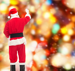 Image showing man in costume of santa claus writing something