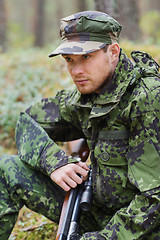 Image showing young soldier or hunter with gun in forest