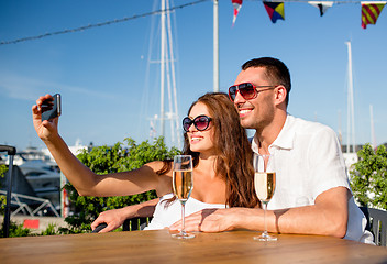 Image showing smiling couple drinking champagne at cafe