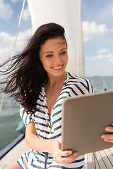 Image showing smiling woman sitting on yacht with tablet pc