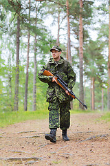 Image showing young soldier or hunter with gun in forest