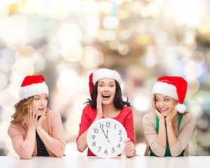 Image showing smiling women in santa helper hat with clock