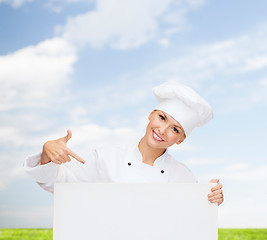 Image showing smiling female chef with white blank board