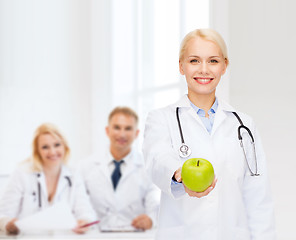 Image showing smiling female doctor with green apple