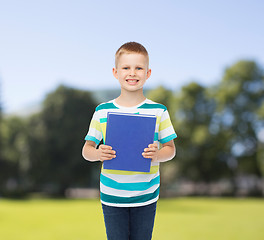 Image showing smiling little student boy with blue book